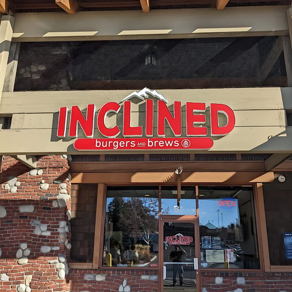The Inclined Burgers and Brews restaurant exterior, featuring a red sign with a mountain logo above the entrance.