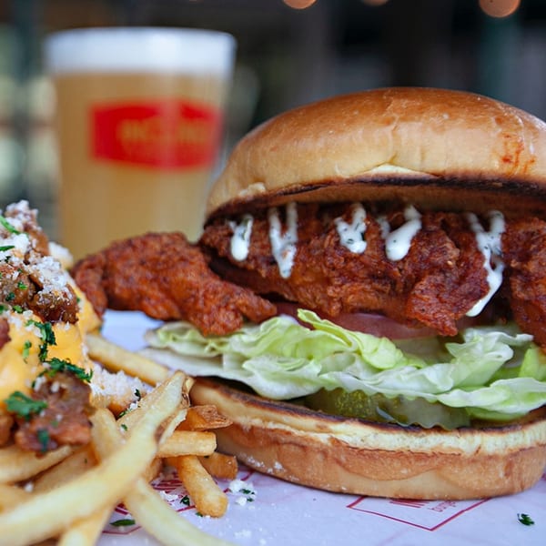 Inclined Burgers and Brews' fried chicken sandwich with fries and a beer.