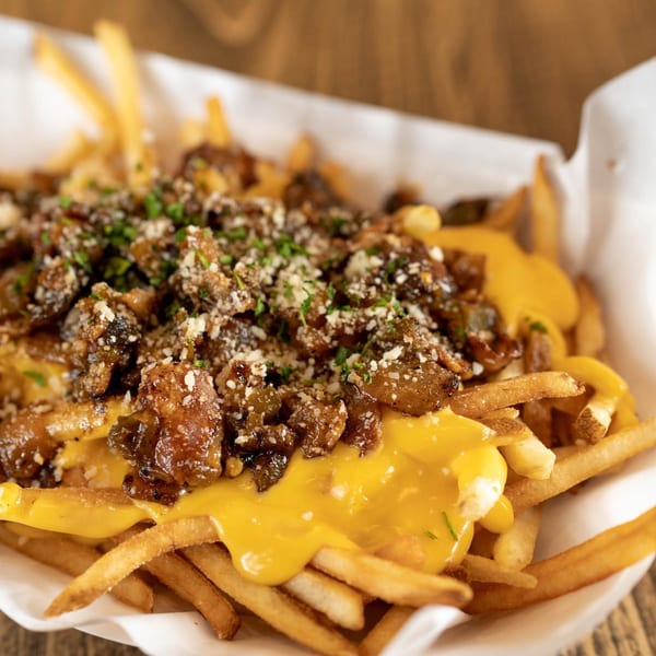 Inclined Burgers and Brews' loaded fries with melted cheese, caramelized onions, and herbs.
